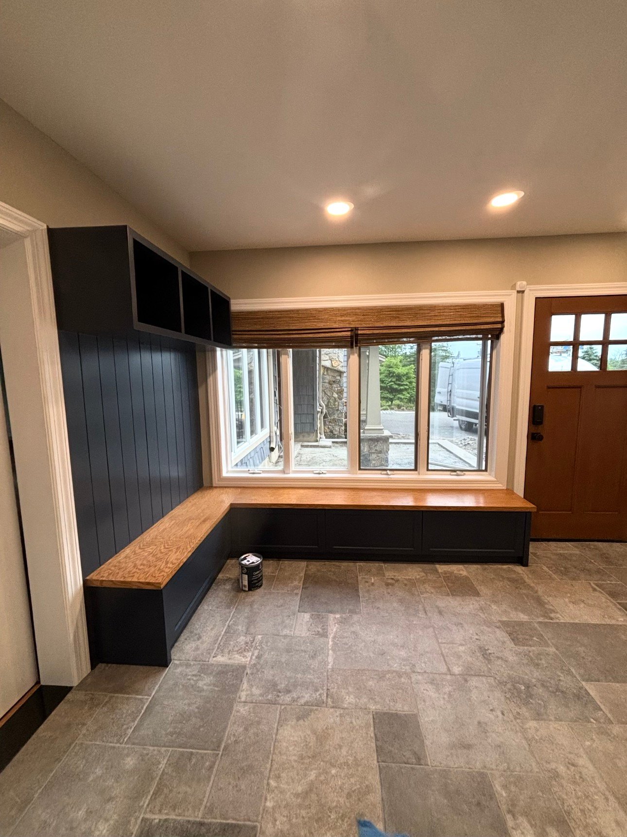 After painting: the same mudroom built-ins in navy, with an oak bench top and white trim